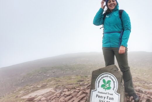 Woman in green coat at top of Pen Y Fan