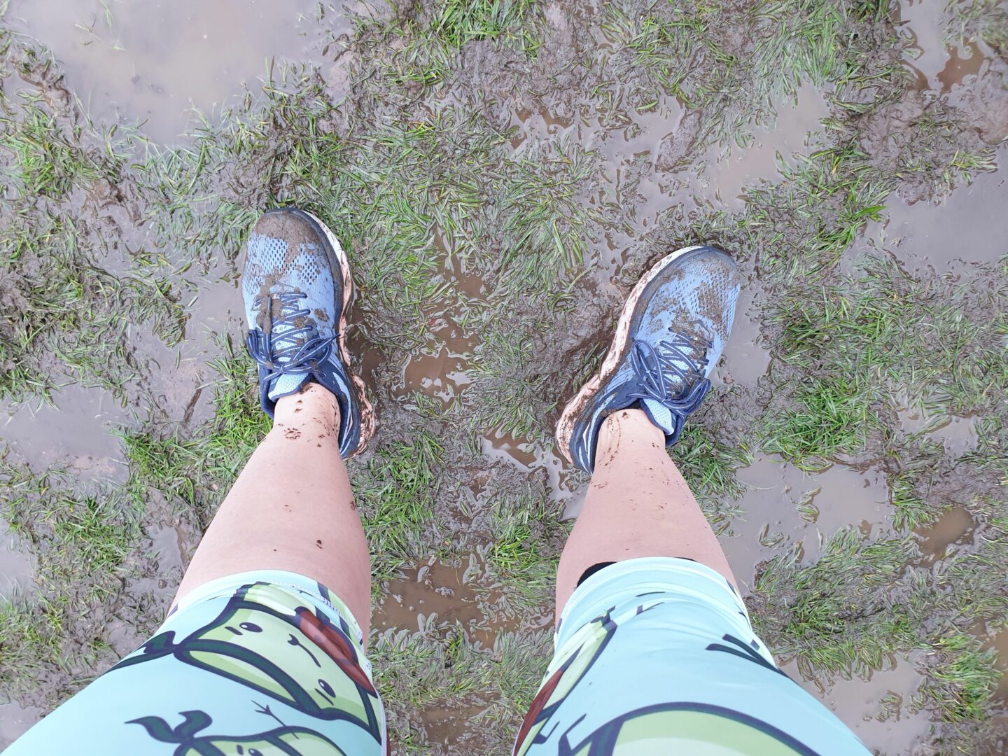 Muddy running shoes in muddy grass field