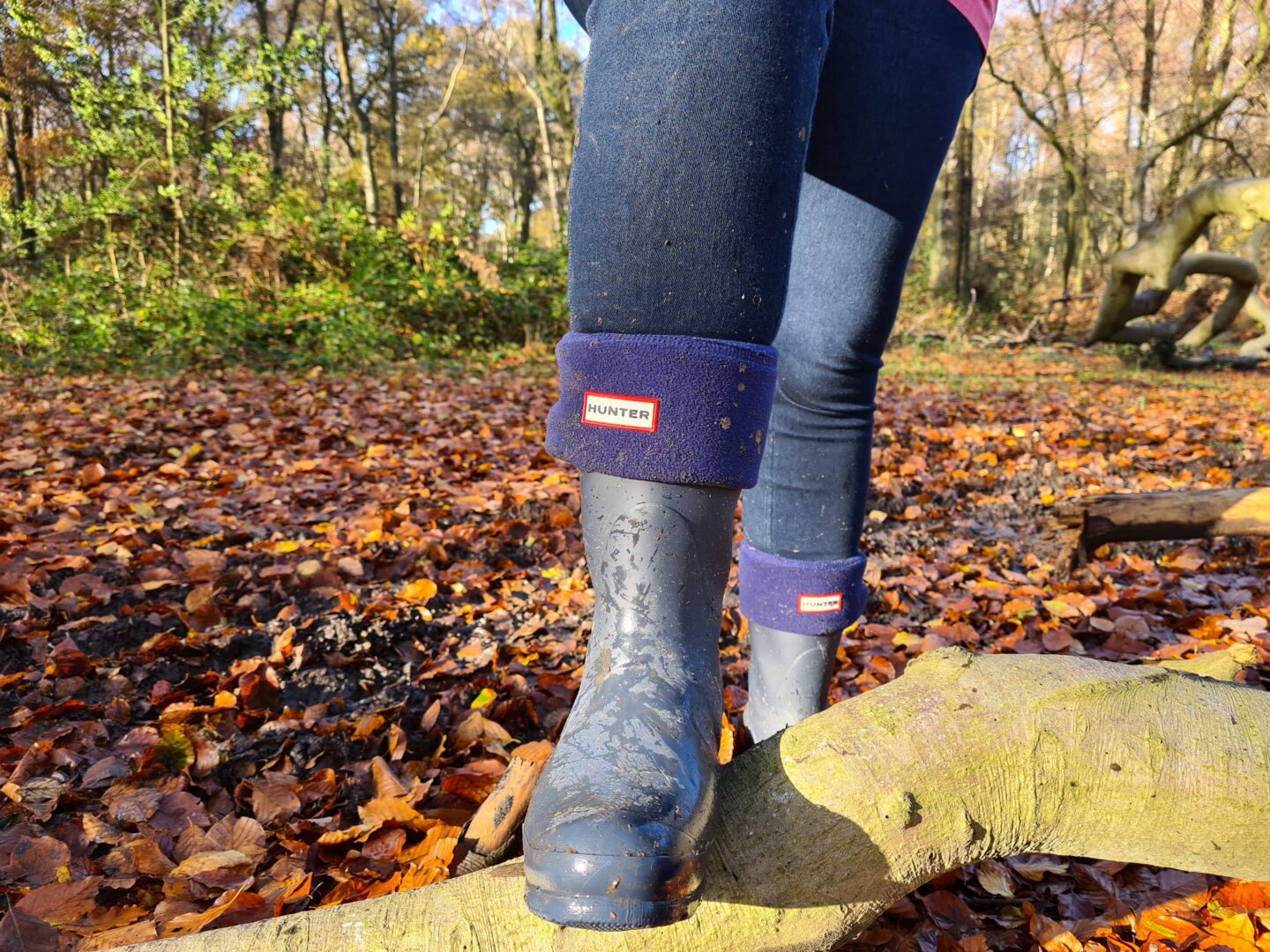 Close up of legs wearing blue Hunter wellies standing in the woods 