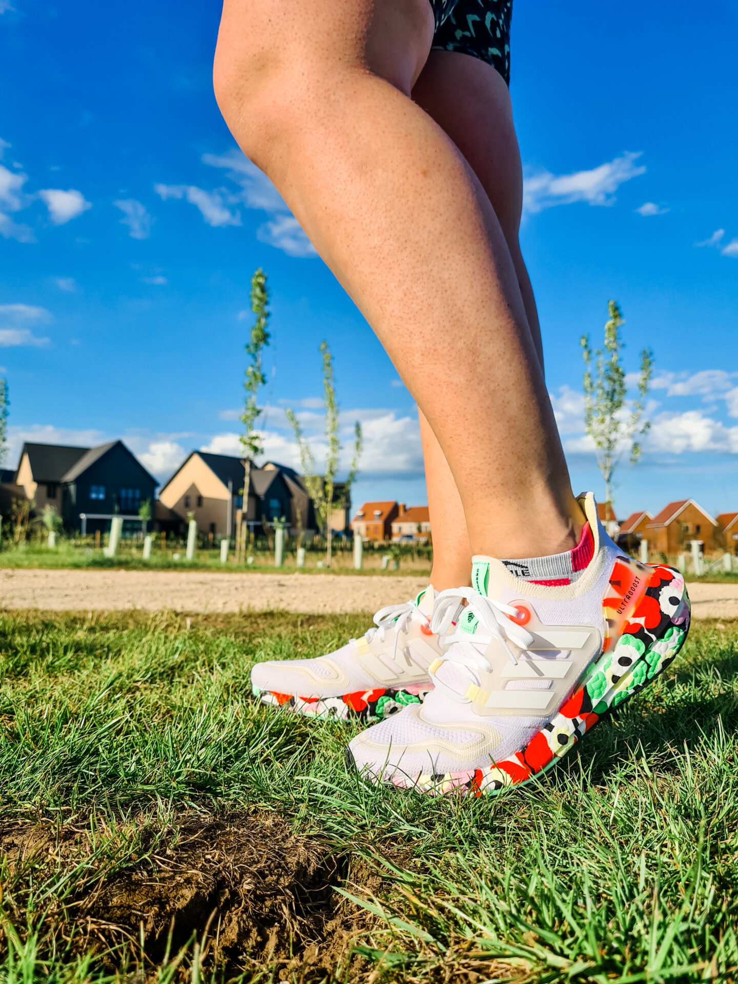 Photo of legs wearing white and flowery patterned running shoes