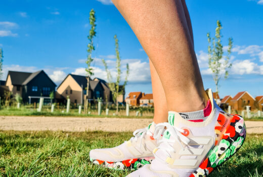 Photo of legs wearing white and flowery patterned running shoes