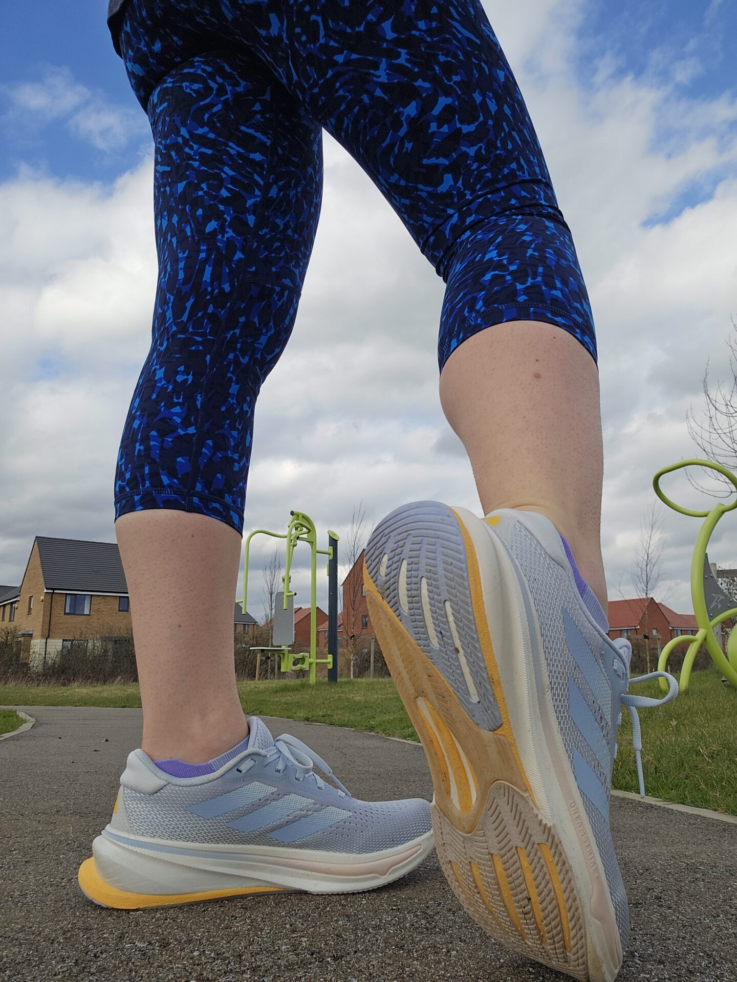 Woman's legs with blue leggings and running shoes 